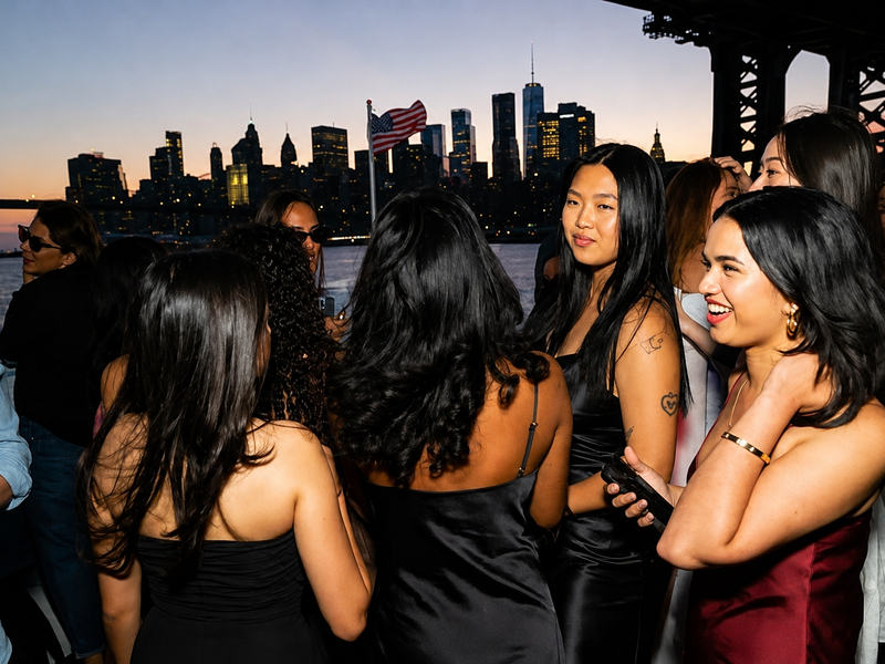 Friends gathering with Manhattan skyline at dusk